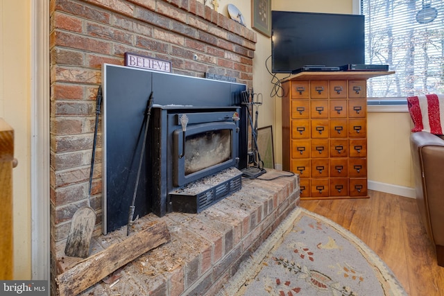 details featuring hardwood / wood-style flooring and a wood stove