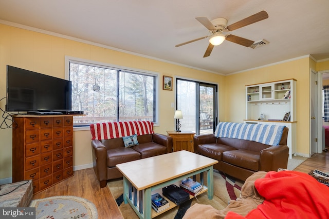 living room featuring light hardwood / wood-style flooring, ceiling fan, a healthy amount of sunlight, and crown molding