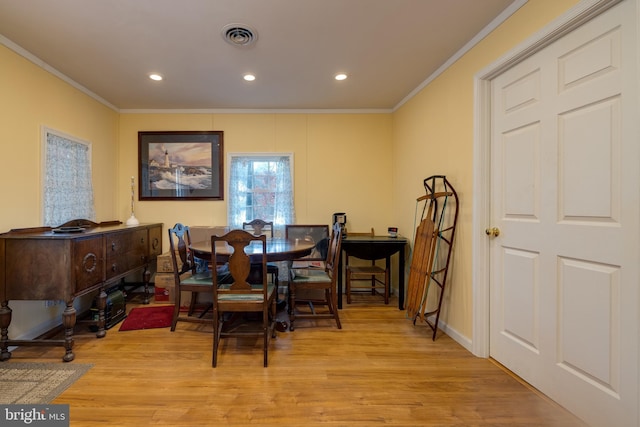 dining area featuring light hardwood / wood-style flooring and ornamental molding