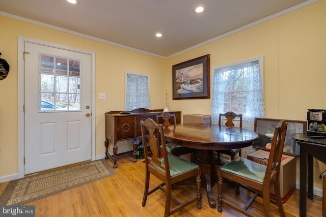 dining area featuring ornamental molding and light wood-type flooring