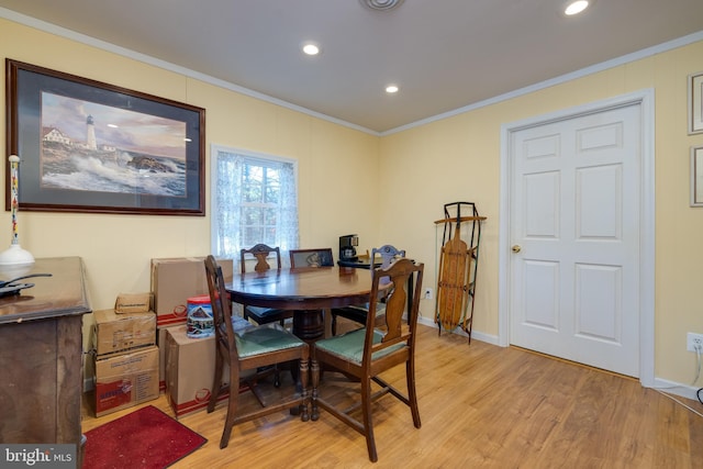 dining area with light hardwood / wood-style floors and ornamental molding