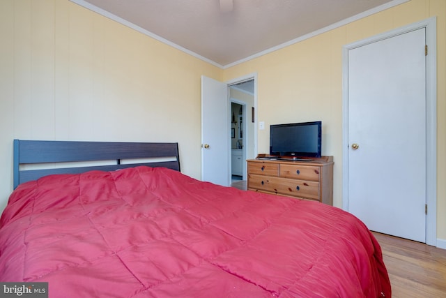 bedroom featuring ceiling fan, light hardwood / wood-style floors, and ornamental molding