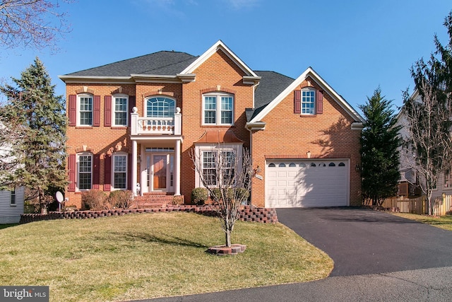 colonial home featuring a front lawn, aphalt driveway, a balcony, an attached garage, and brick siding