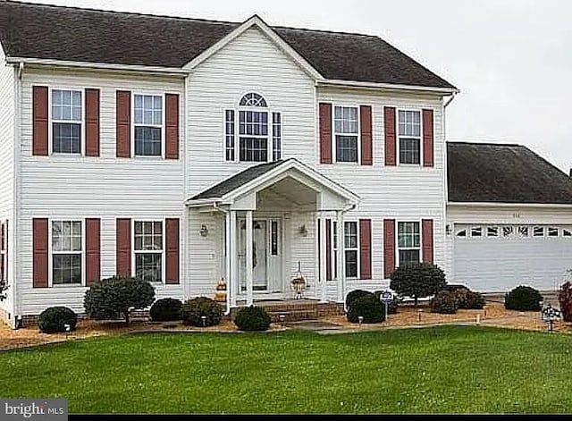 colonial-style house with a front yard and a garage