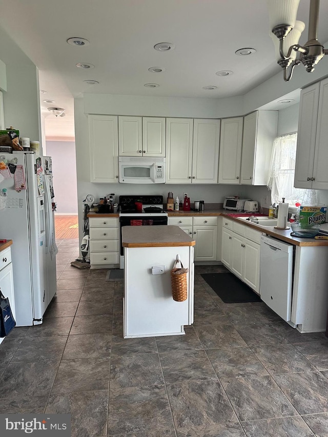 kitchen featuring a center island, white cabinetry, white appliances, and sink