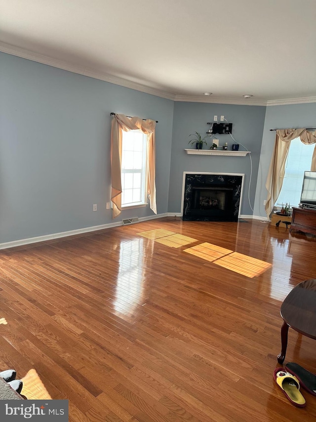 unfurnished living room featuring wood-type flooring and crown molding