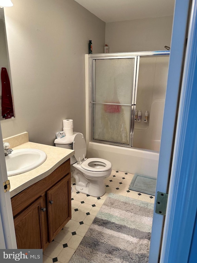 full bathroom with tile patterned flooring, vanity, toilet, and enclosed tub / shower combo