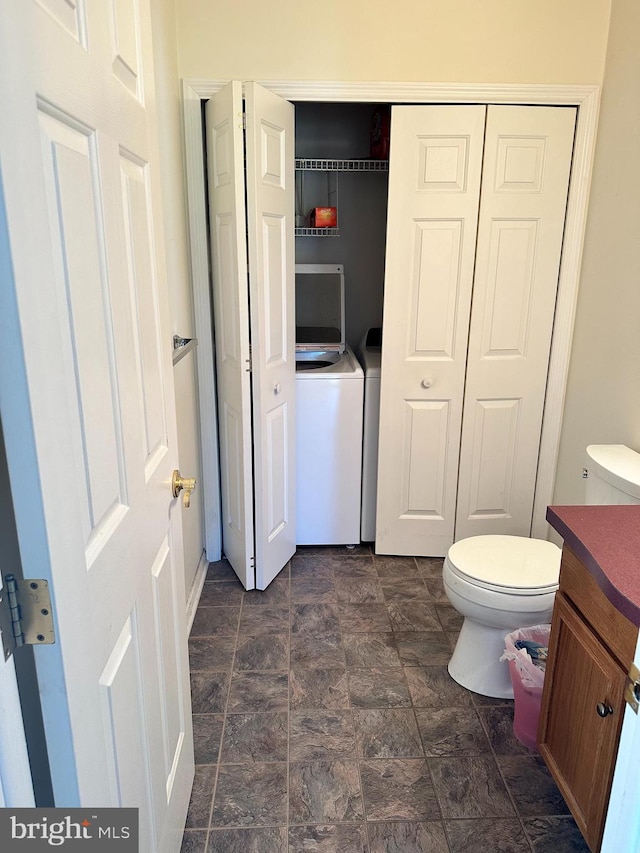 bathroom with vanity, washer / clothes dryer, and toilet