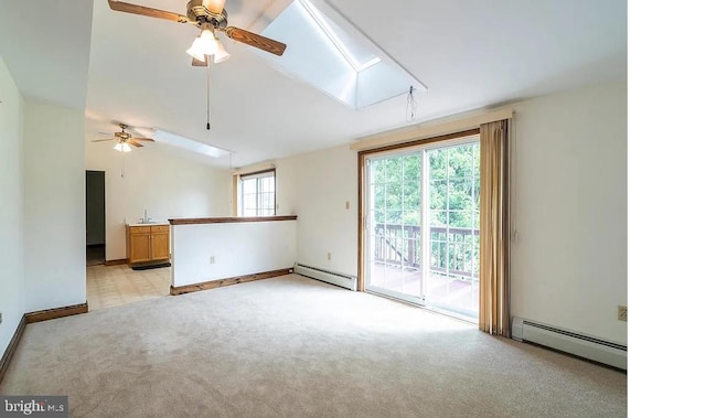 spare room featuring a healthy amount of sunlight, lofted ceiling with skylight, and baseboard heating