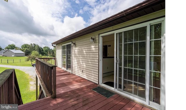 wooden deck featuring a yard and a baseboard radiator