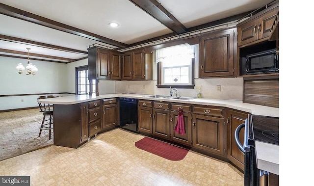 kitchen with kitchen peninsula, hanging light fixtures, a healthy amount of sunlight, and black appliances