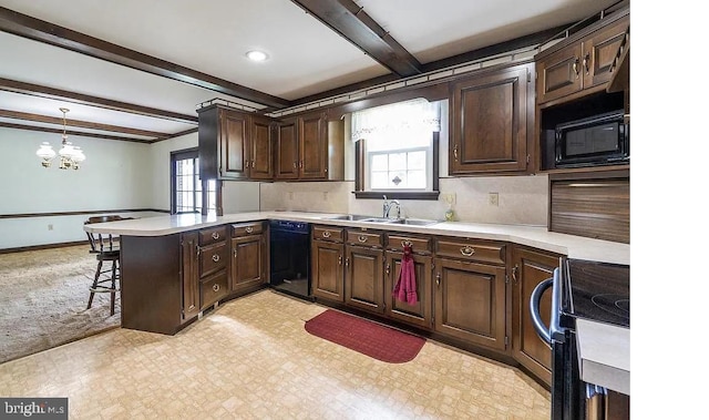 kitchen featuring black appliances, plenty of natural light, kitchen peninsula, and decorative light fixtures