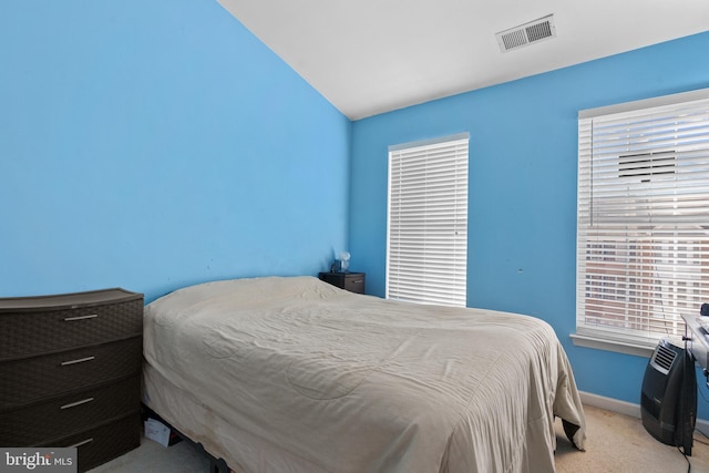 bedroom featuring light colored carpet and vaulted ceiling