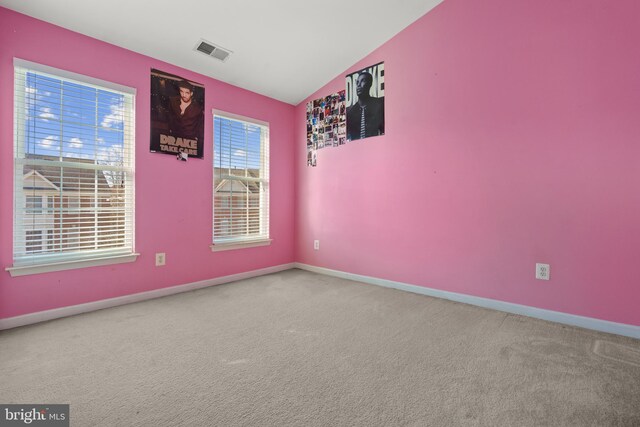 carpeted empty room with lofted ceiling