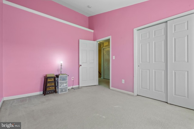 unfurnished bedroom with light carpet and a closet