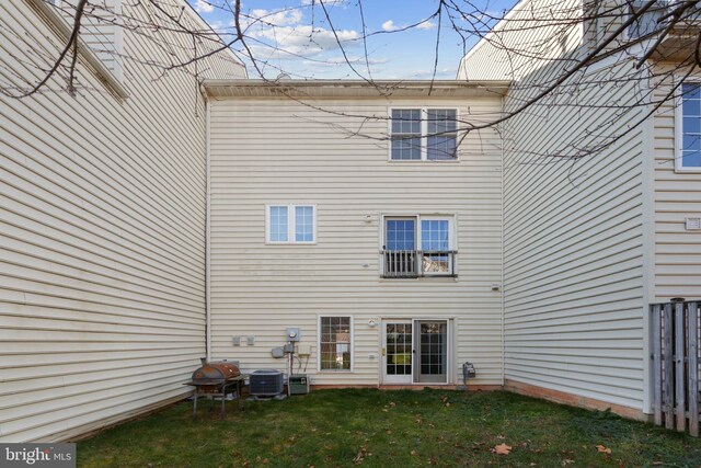 rear view of property featuring a yard and central AC unit