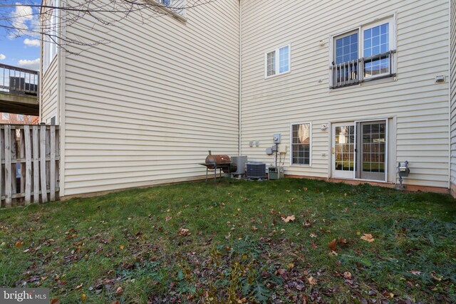 back of house featuring central AC and a yard