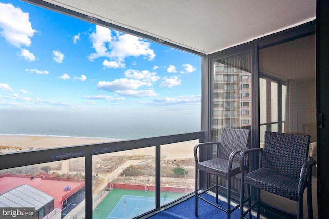 balcony featuring a water view and a view of the beach