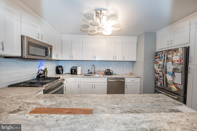 kitchen with sink, white cabinetry, backsplash, and appliances with stainless steel finishes