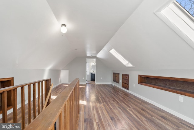 bonus room with vaulted ceiling with skylight and dark hardwood / wood-style floors