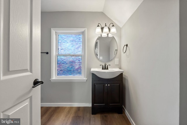 bathroom with hardwood / wood-style floors, vanity, and lofted ceiling