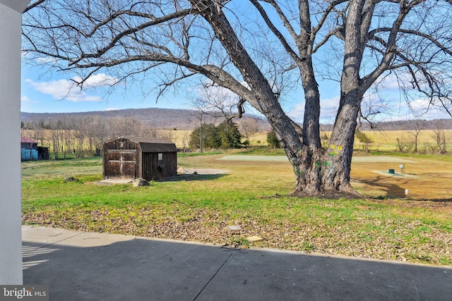 view of yard with a rural view and a storage shed