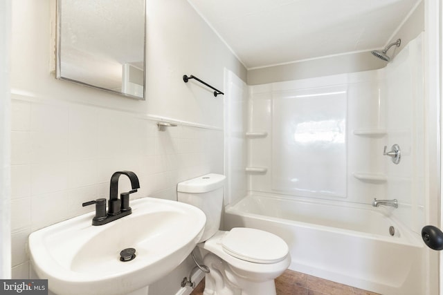 full bathroom featuring bathing tub / shower combination, toilet, tile walls, and sink