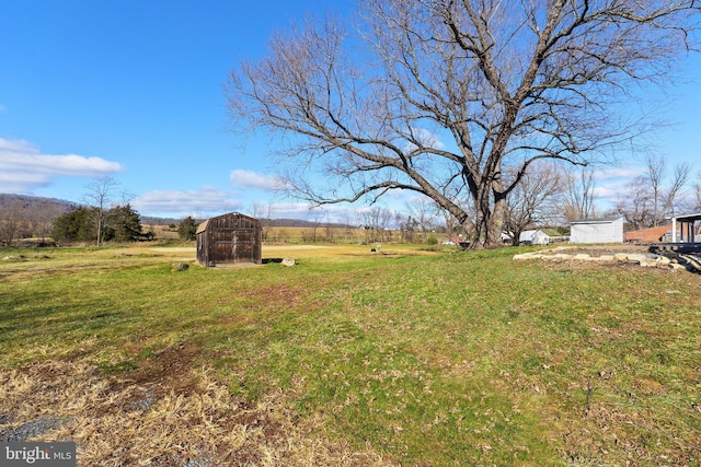 view of yard featuring a rural view and an outdoor structure