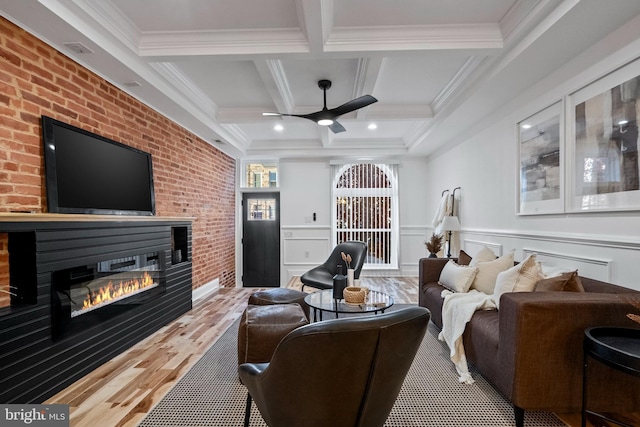 living room featuring beamed ceiling, crown molding, ceiling fan, and coffered ceiling