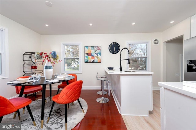 dining area featuring plenty of natural light, light hardwood / wood-style floors, and sink