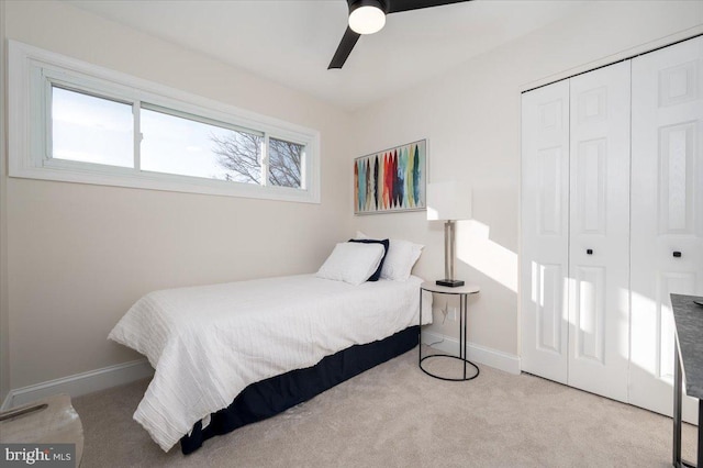 bedroom with ceiling fan, a closet, light colored carpet, and multiple windows