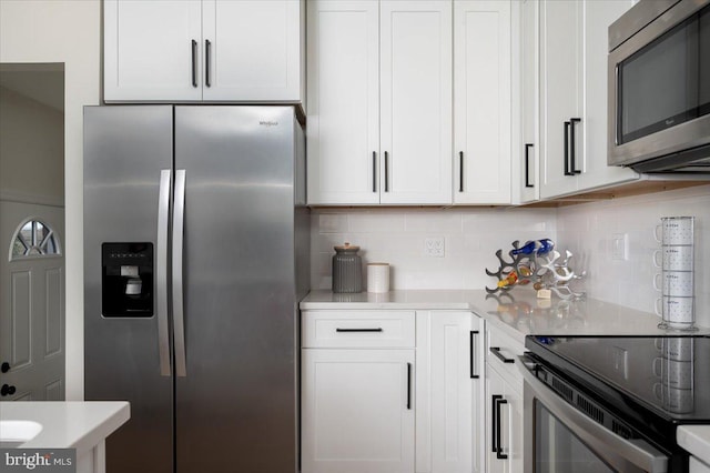 kitchen with white cabinets, stainless steel appliances, and tasteful backsplash