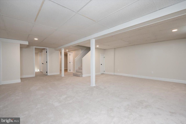 basement with a paneled ceiling and carpet flooring