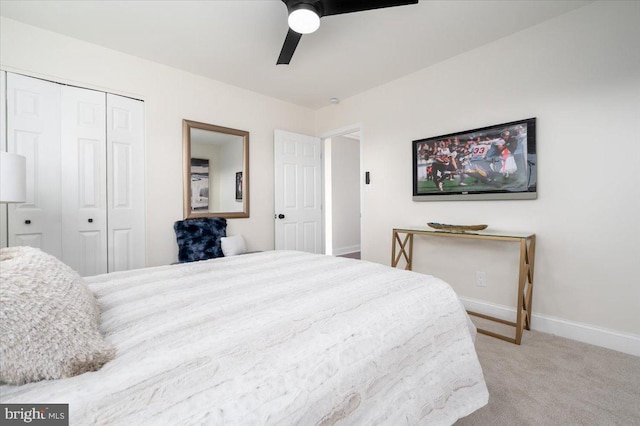 bedroom with ceiling fan, light colored carpet, and a closet