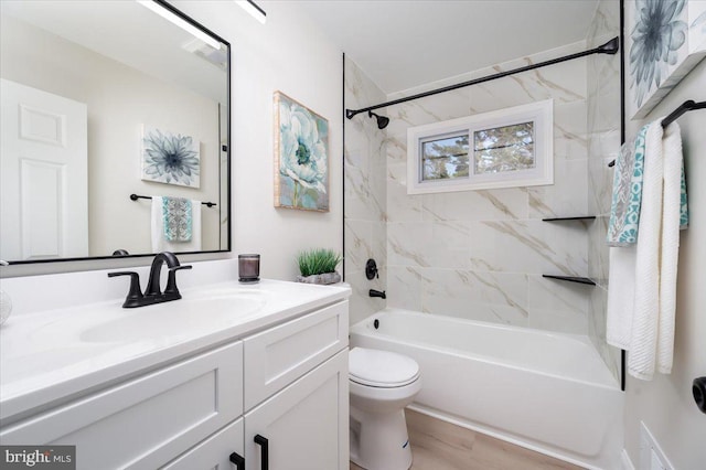 full bathroom with vanity, wood-type flooring, tiled shower / bath combo, and toilet