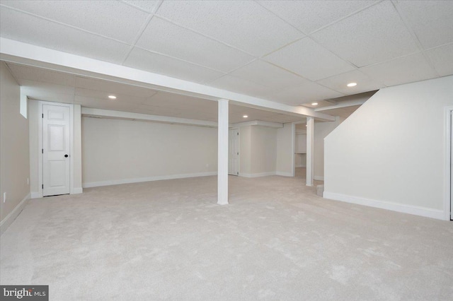 basement featuring carpet and a drop ceiling