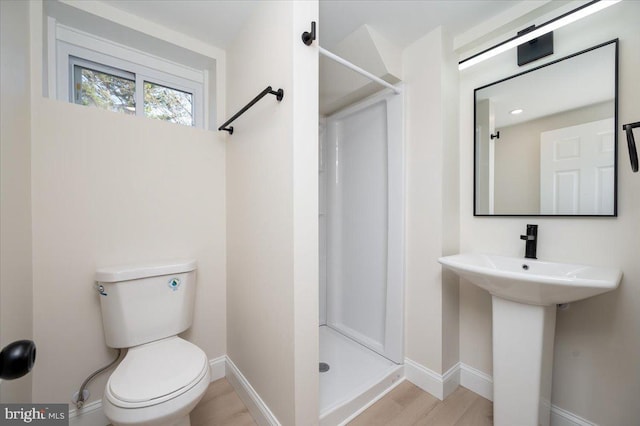 bathroom with walk in shower, sink, wood-type flooring, and toilet