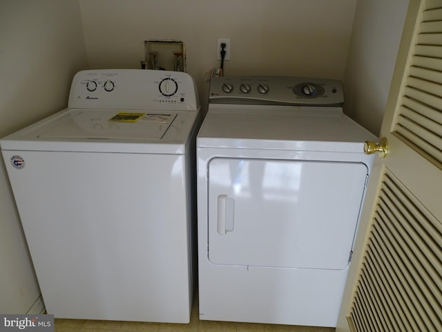 laundry room featuring light tile patterned floors and washer and clothes dryer