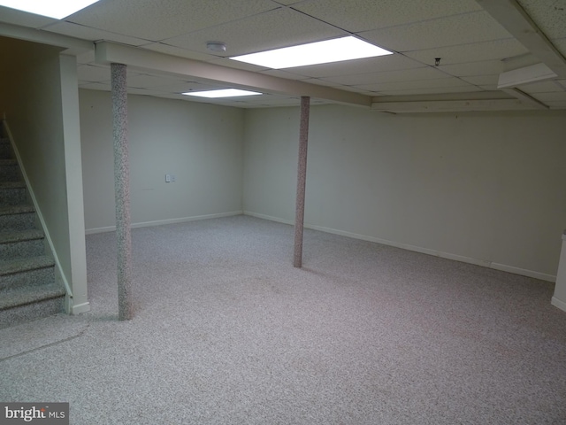 basement featuring a paneled ceiling and carpet