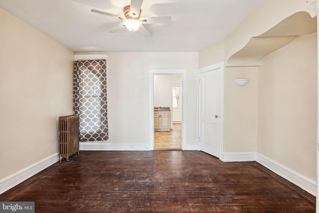 spare room with radiator, ceiling fan, and hardwood / wood-style flooring