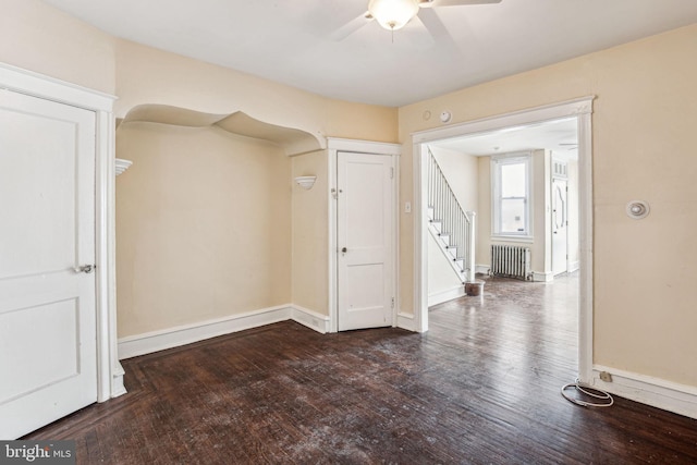 empty room with radiator, ceiling fan, and dark wood-type flooring