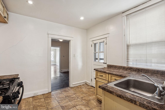 kitchen featuring gas stove, a wealth of natural light, sink, and light hardwood / wood-style floors