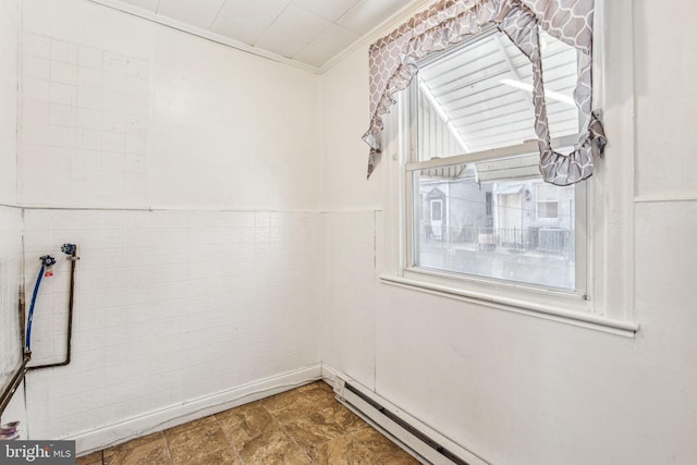 unfurnished room featuring ornamental molding and a baseboard heating unit