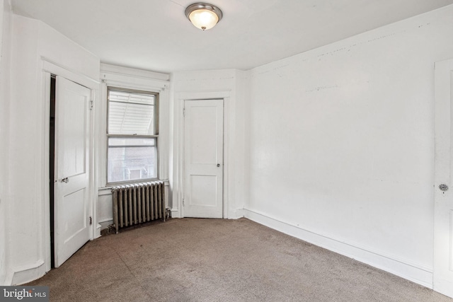 spare room with carpet floors and radiator