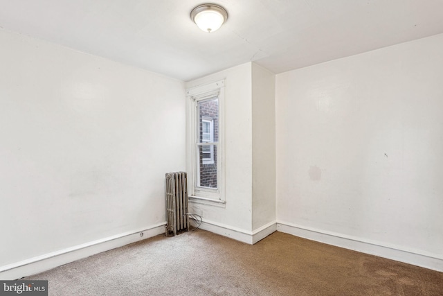 unfurnished room featuring carpet flooring and radiator heating unit