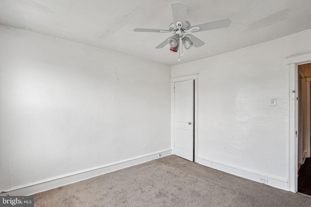 empty room featuring ceiling fan and carpet