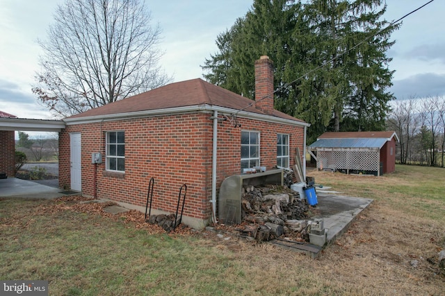 view of property exterior with a yard and an outdoor structure