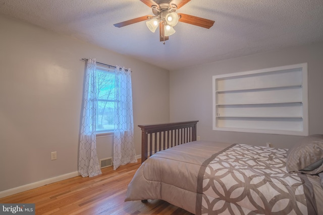 bedroom featuring ceiling fan, a textured ceiling, and light hardwood / wood-style flooring