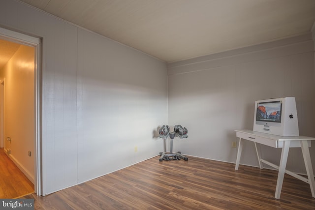 misc room featuring dark wood-type flooring and wooden walls