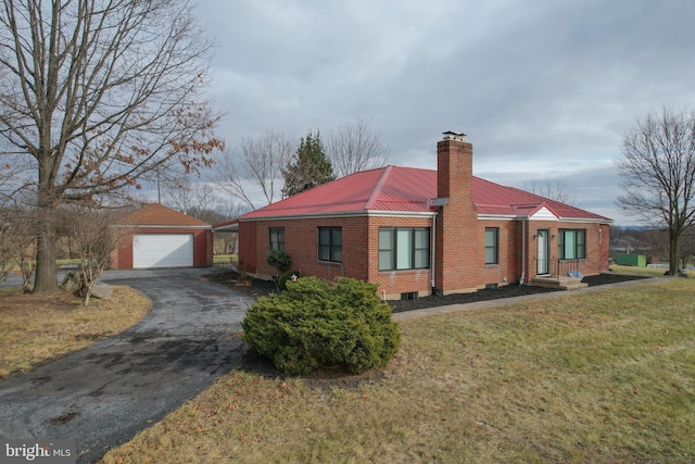 view of front of home featuring a front yard, an outdoor structure, and a garage